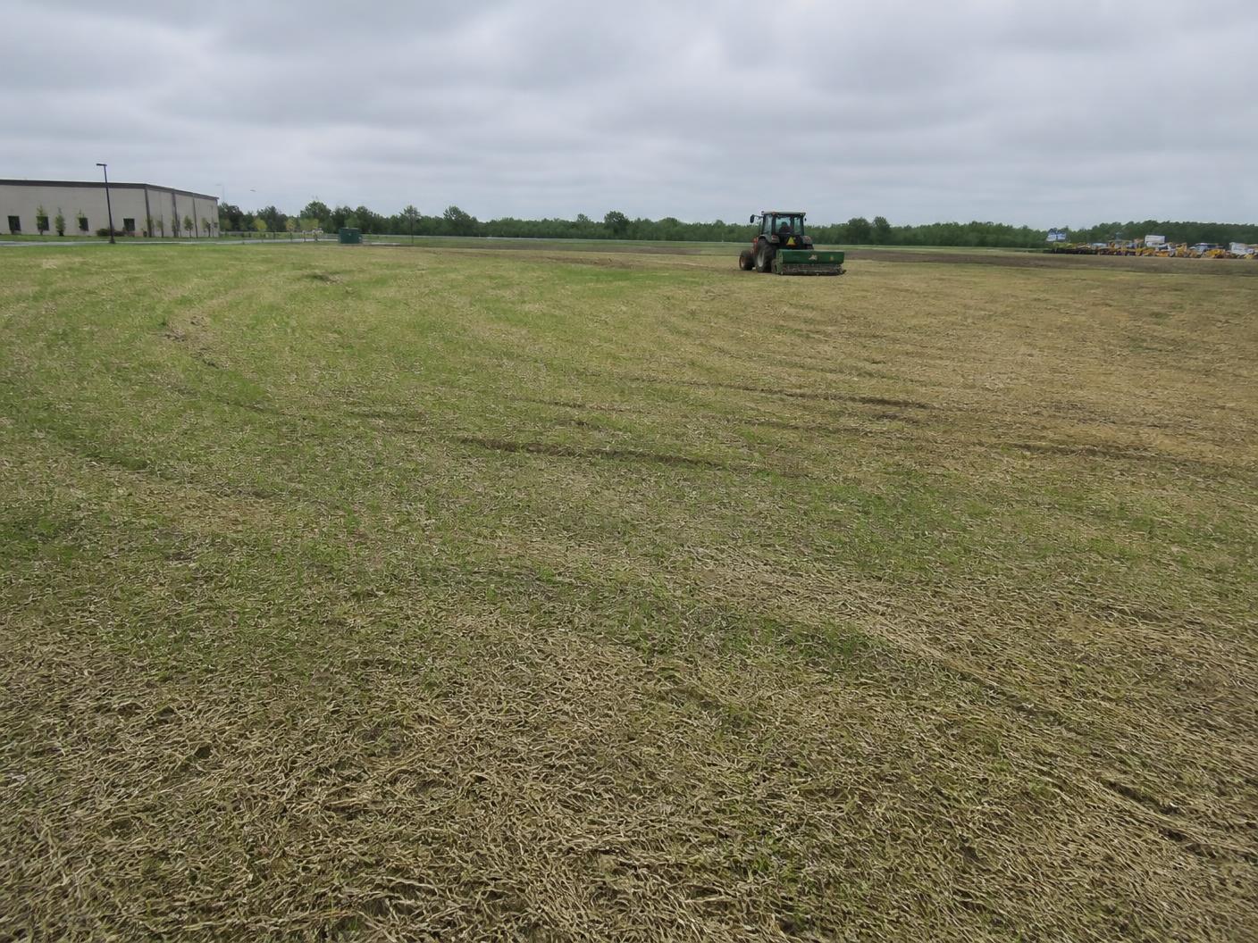 Tractor seeding and restoring a large graded commercial land parcel